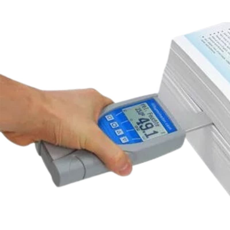 Close-up of a hand using a digital moisture meter 'RH5' to measure a stack of white paper, displaying a '49.1%' humidity reading on the screen.