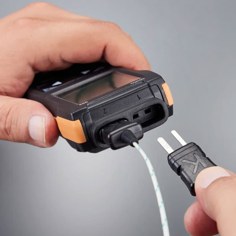 Close-up of thermocouple probe being plugged into Testo 922 thermometer input port.