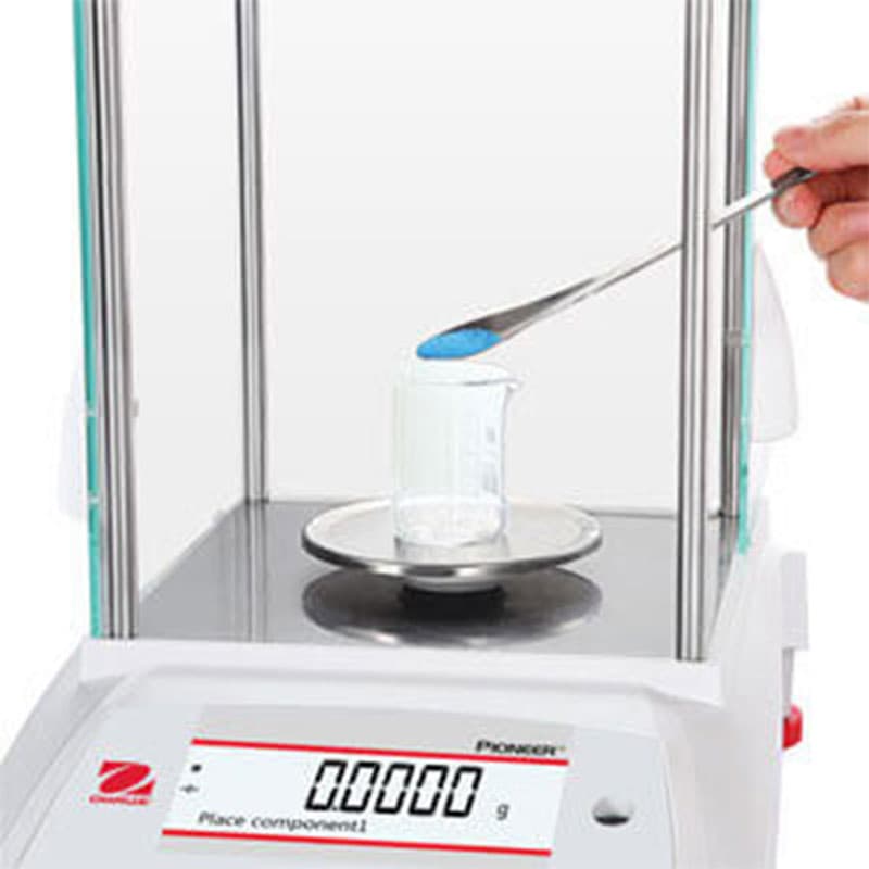 Sample being added to a container on an OHAUS Pioneer analytical balance.