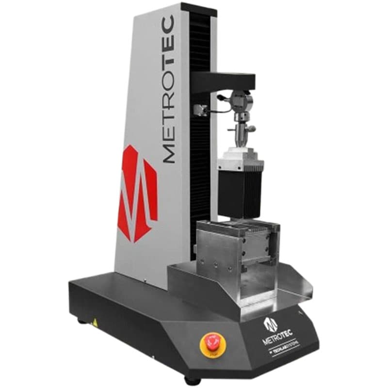 METROTEC food texture and firmness analyser testing machine with a vertical column, gripping mechanism, and a safety stop button on the base.
