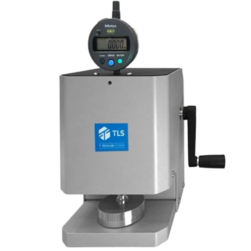 Thickness gauge with a Mitutoyo digital display, a manual hand crank, and a circular sample plate, branded with the TLS logo.