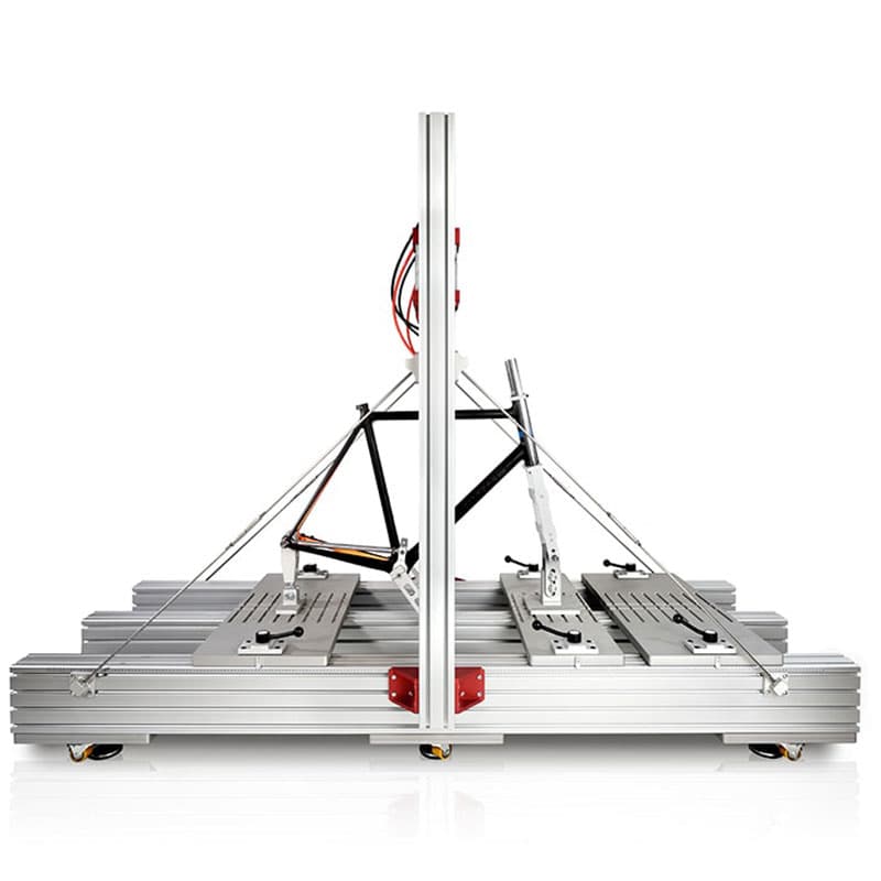 This image provides another perspective of the bike testing rig, this time from a side angle. The sleek and industrial setup is clearly visible, showcasing the precision of the machinery involved.