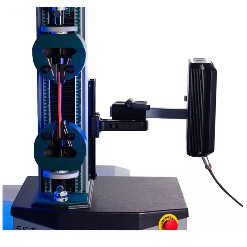 This image features a mechanical testing machine, likely used for tensile testing, with a sample clamped between two grips. The machine has a vertical structure, with the grips holding a thin material or wire. On the right, the Vector U200 extensometer is attached to measure the elongation of the material. The background is plain white, with the focus entirely on the equipment. The lighting is even, giving the image a clean and technical appearance.