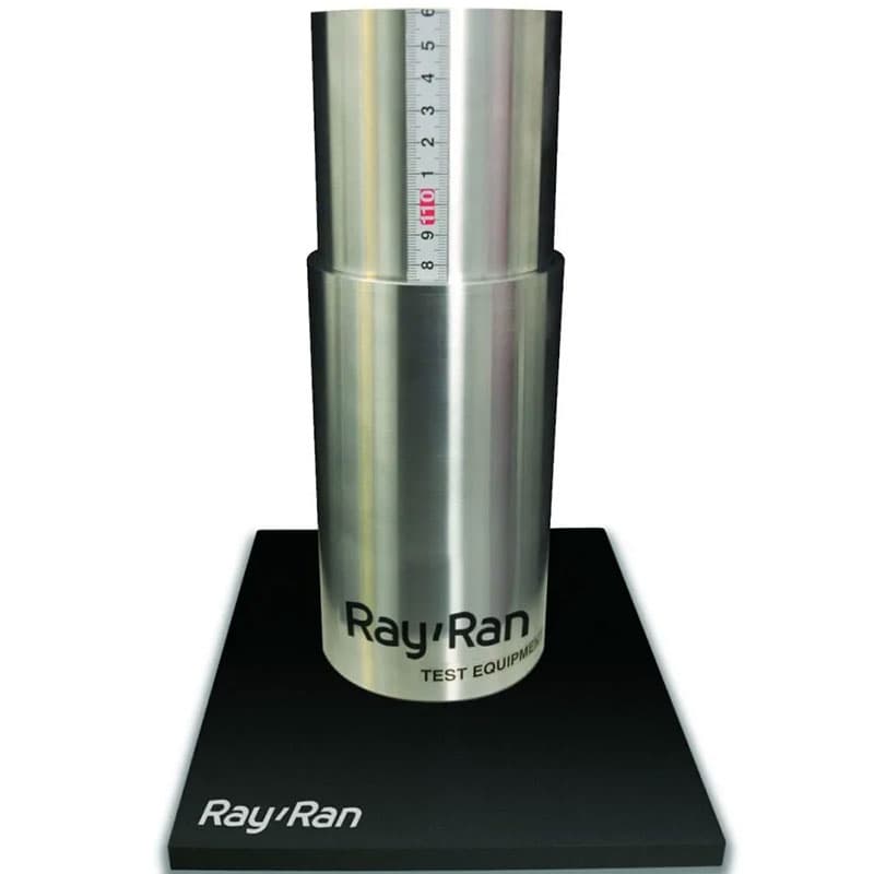 Stainless steel cylindrical container with a volume scale, part of the Ray Ran flow tester, displayed on a branded black base.