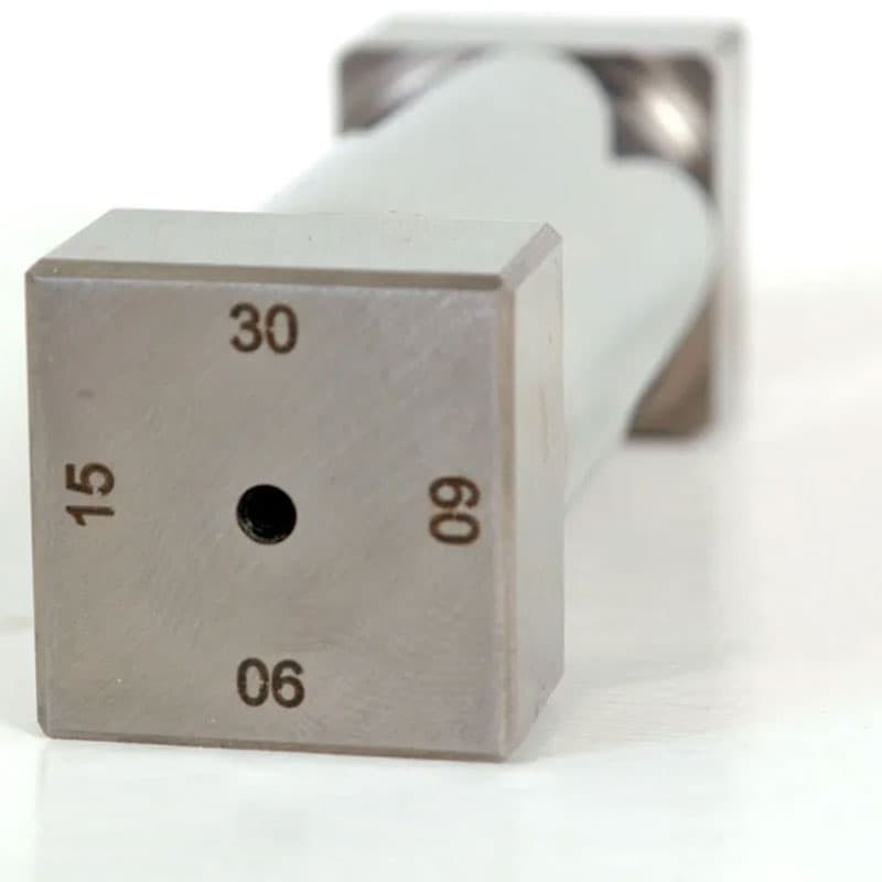 Front view of a square end of a metallic instrument with engraved numbers (30, 60, 90) and a central hole.
