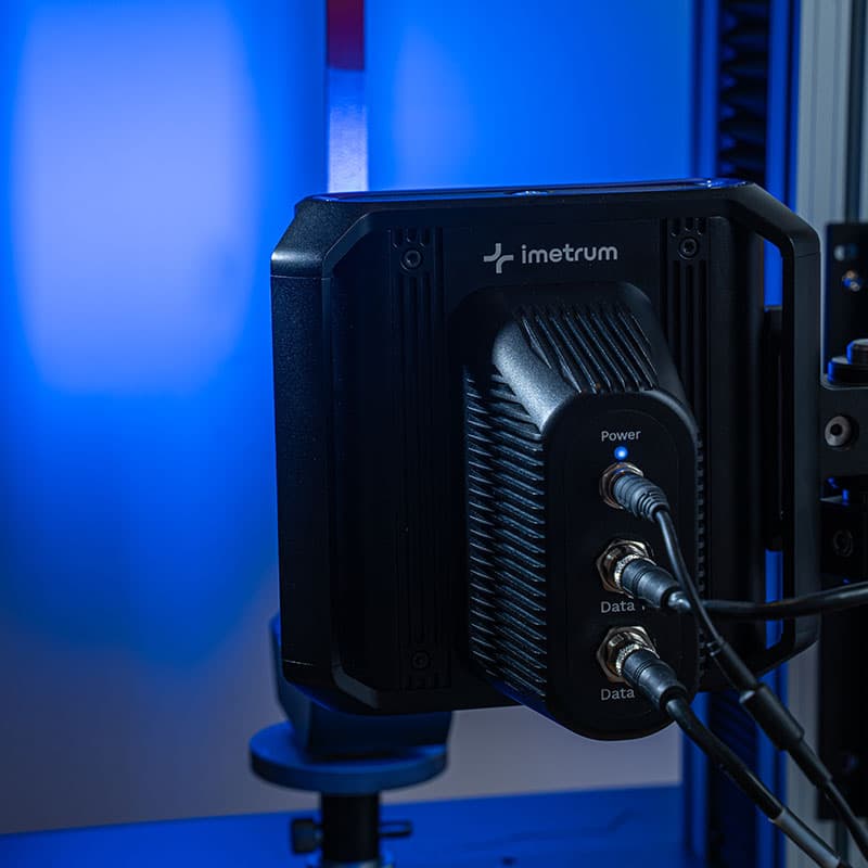 UVX3D device mounted on a testing rig, showing connected power and data cables with blue light in the background.