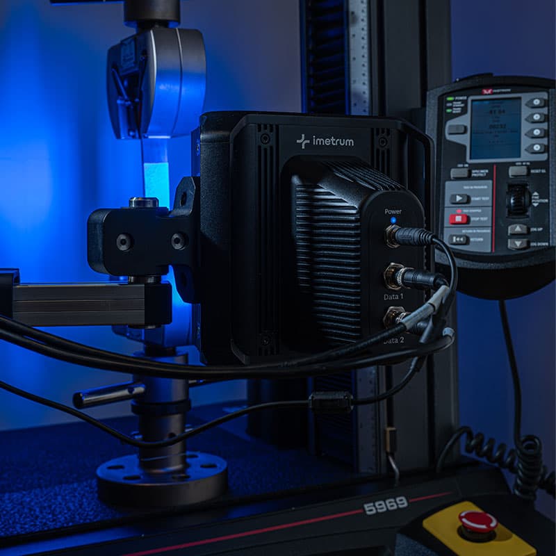 UVX3D device on a testing rig with a control panel in the background, illuminated by blue light.