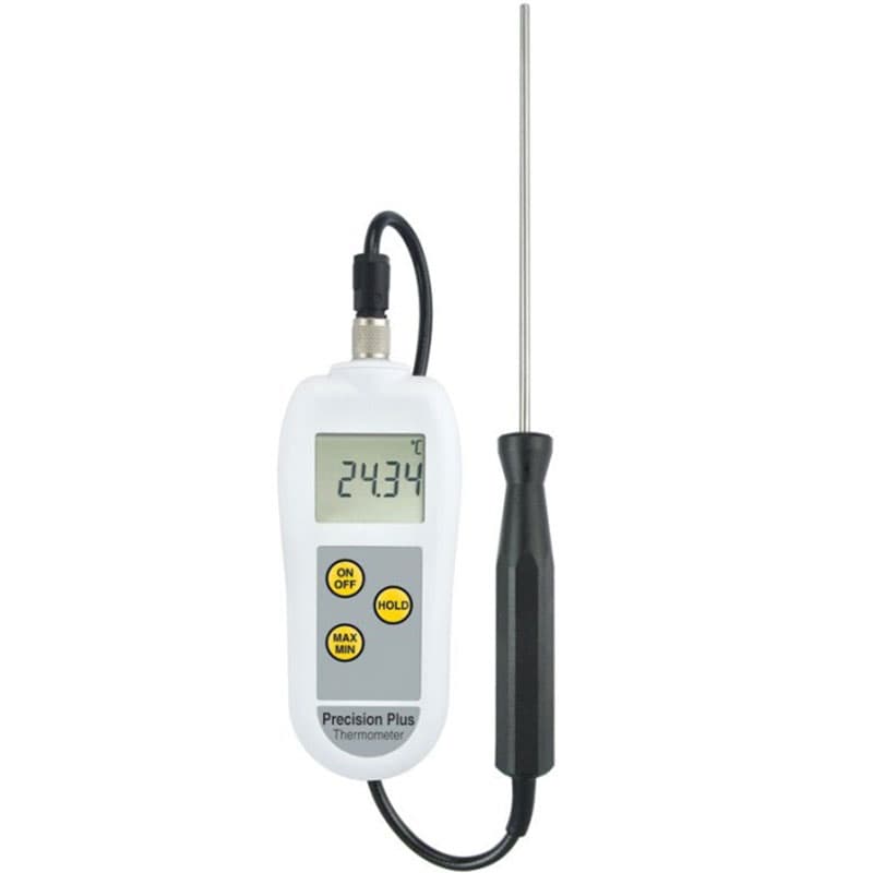 A Precision Plus Thermometer with a white body, digital LCD screen reading 24.34°C, and a black-handled stainless steel probe connected via a cable.