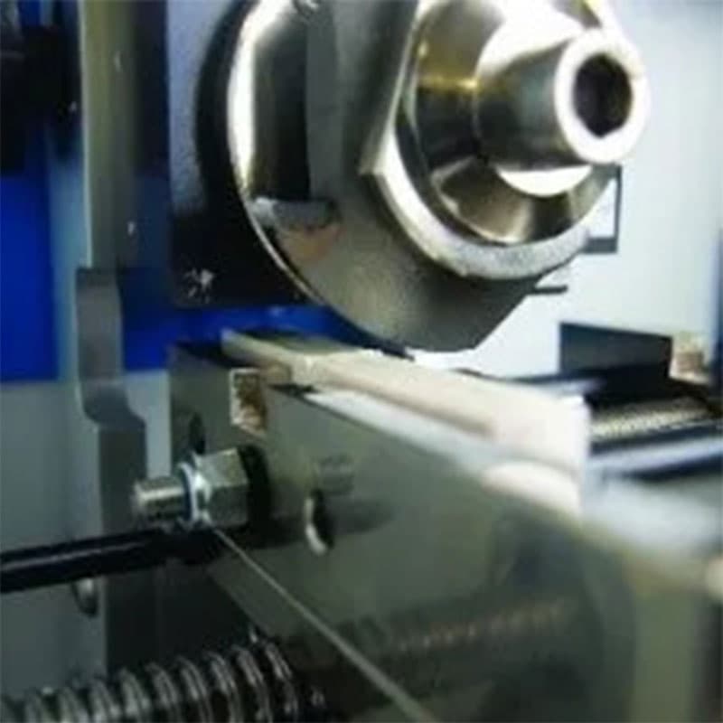 A close-up of the cutting blade inside the Ray-Ran Notching Cutter, precisely notching a sample specimen for impact testing.