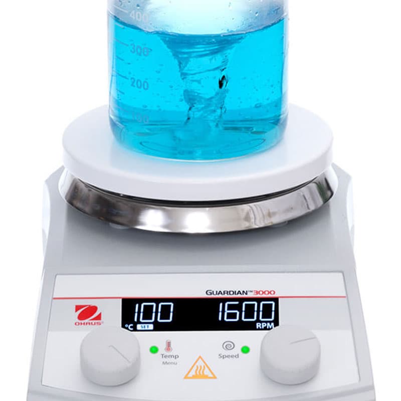 Top view of Guardian 3000 hotplate stirrer with round top stirring blue liquid at high speed.