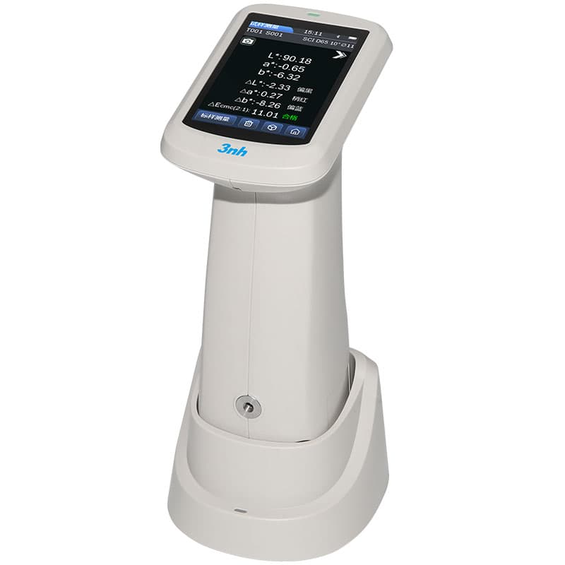 Handheld spectrophotometer in a docking base displaying colour measurement data on its touchscreen.