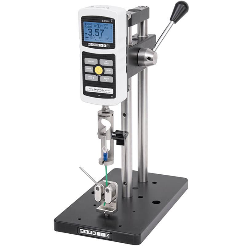 Mark-10 ES10 manual force test stand with digital force gauge, lever-operated carriage, and grips configured for tension testing.