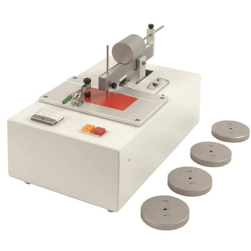 Clemen Scratch Hardness Tester with adjustable scratching mechanism, specimen holder, operating controls and four circular test weights for coating hardness evaluation.