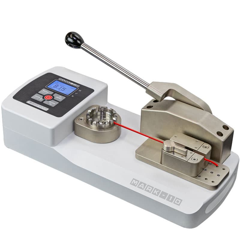 Operator using the manual lever on a Mark-10 WT-205 to perform a wire crimp pull test while the force is displayed digitally.