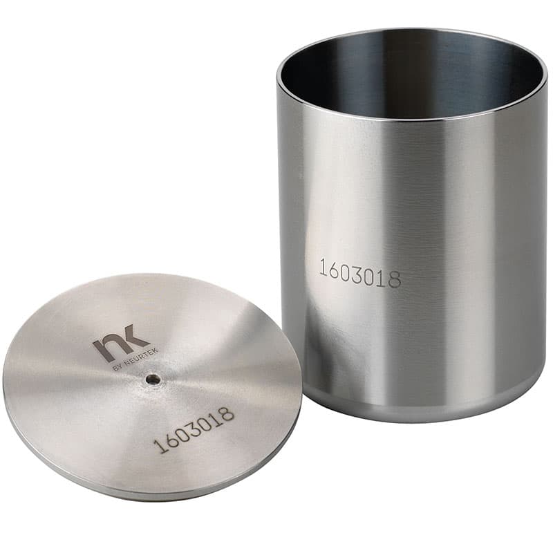 Stainless steel liquid pycnometer with cylindrical sample cup and precision lid featuring a central overflow opening for density and specific gravity measurement.