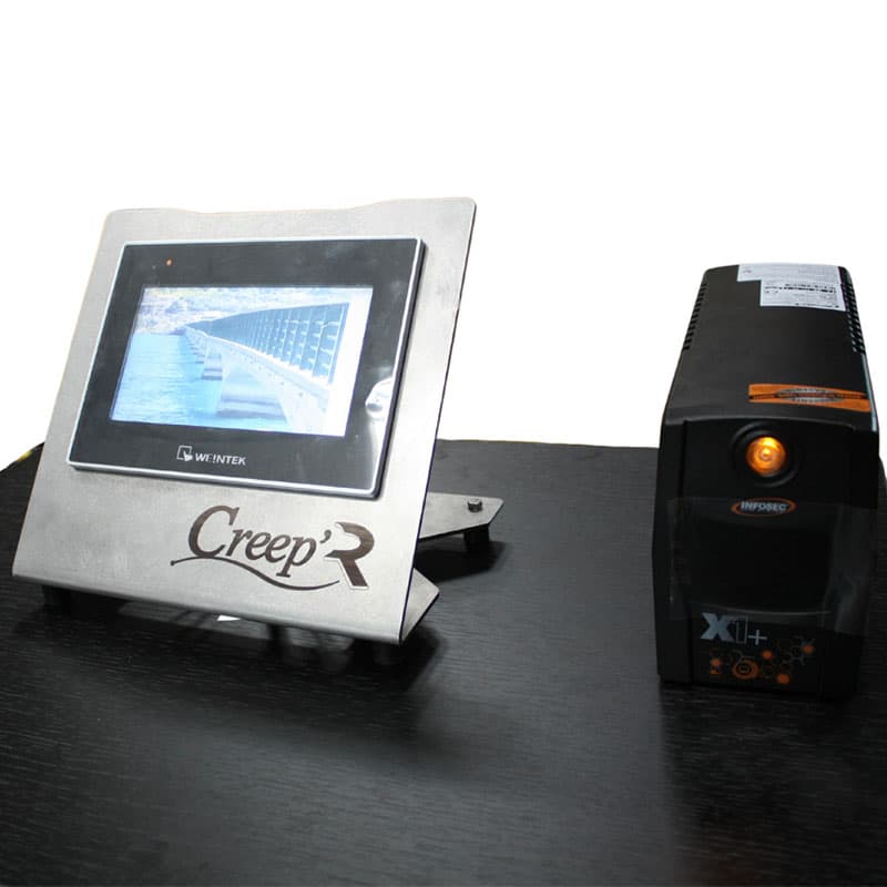 CREEP'R touchscreen operator terminal for monitoring and controlling creep frame testing, shown beside a power supply unit.