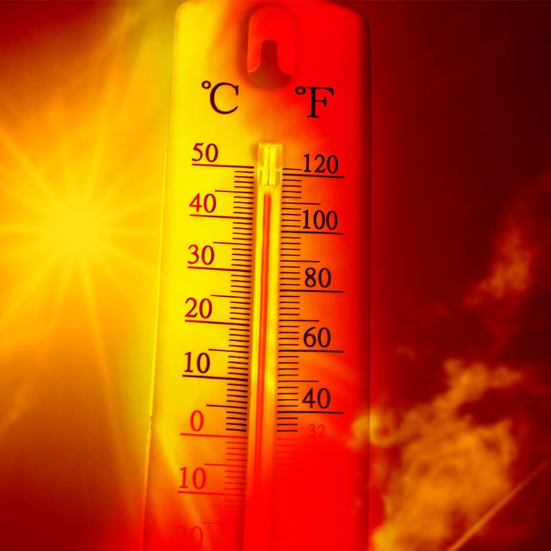 A thermometer showing high temperatures (over 40°C/100°F) against a fiery red and orange background, symbolizing extreme heat or a heatwave.
