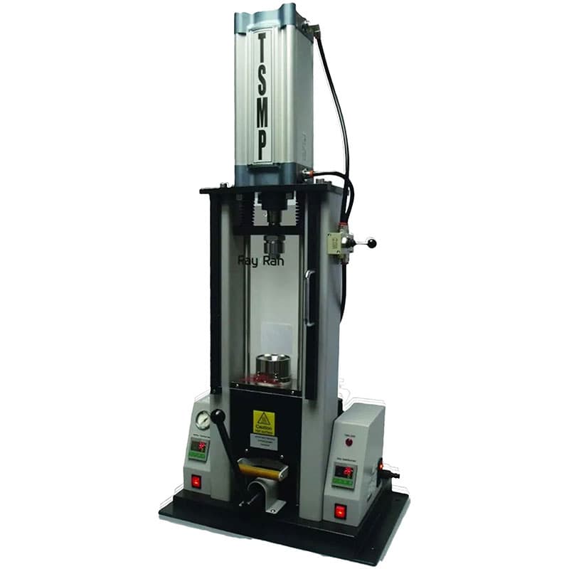 Test Sample Moulding Press (TSMP) machine with vertical press mechanism, transparent safety guard, digital control panels, and hydraulic components for laboratory test specimen preparation.