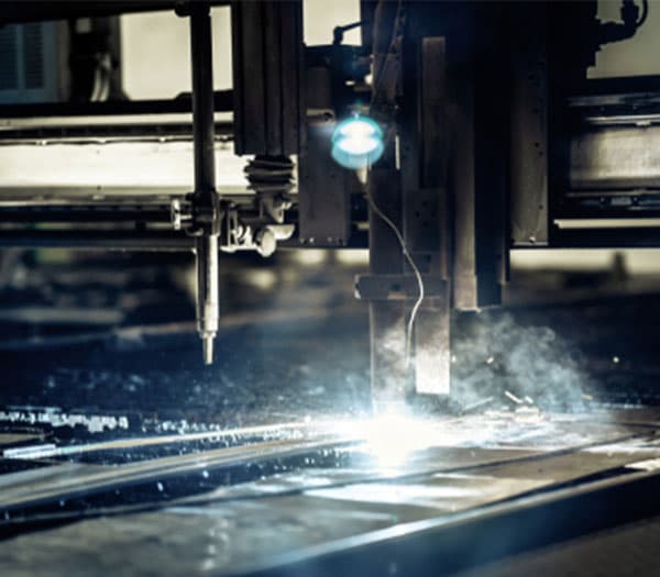 Industrial plasma cutting machine cutting a metal plate.