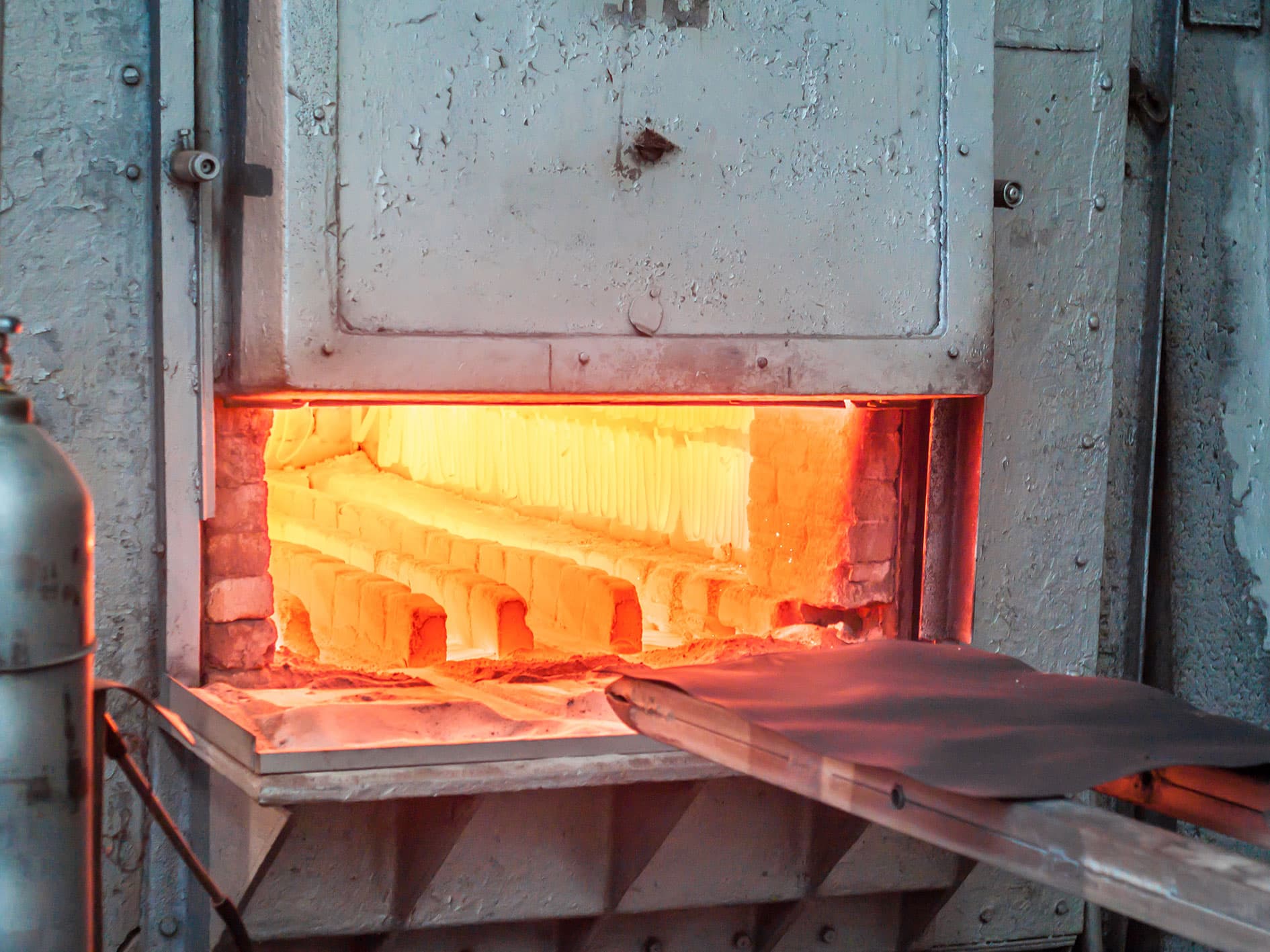 Open industrial furnace glowing orange during high-temperature calibration or heat-treatment.