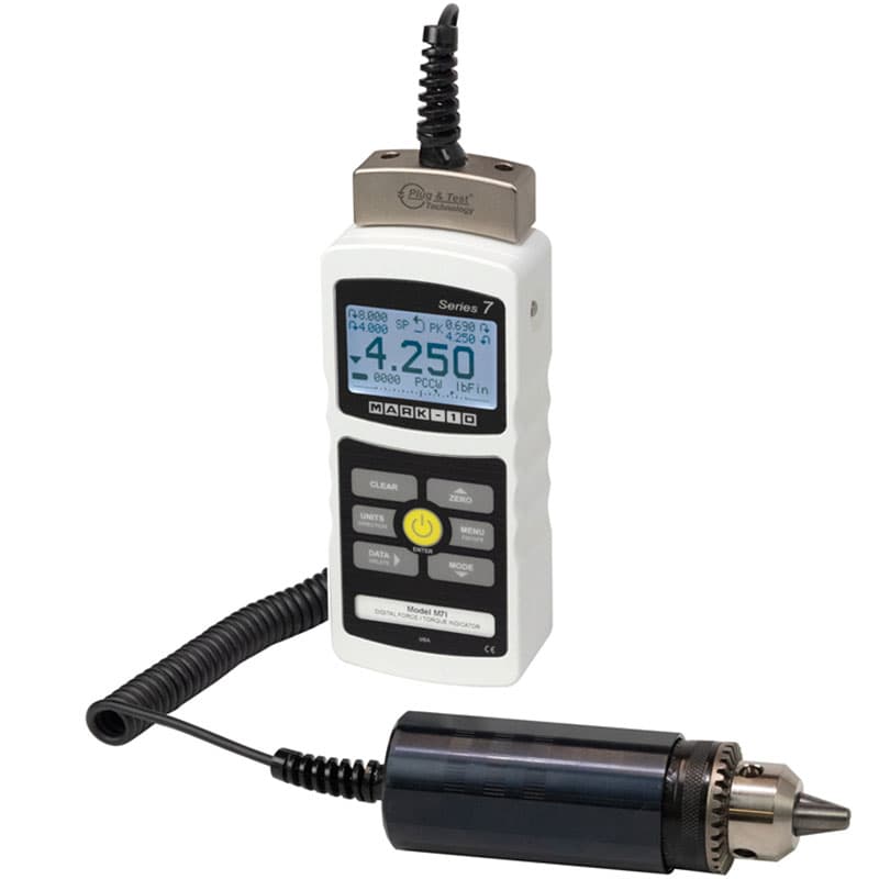 Mark-10 M7i digital indicator connected by a coiled cable to a remote Plug & Test torque sensor with chuck.