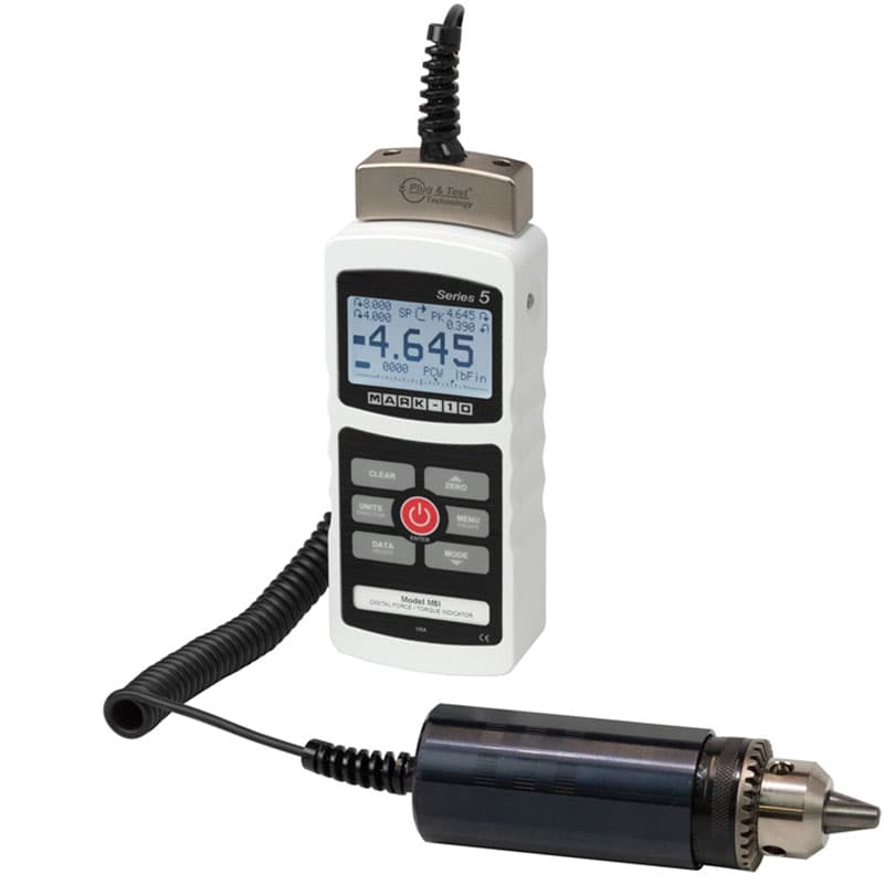 Mark-10 M5i digital indicator connected by a coiled cable to a remote Plug & Test torque sensor with chuck.