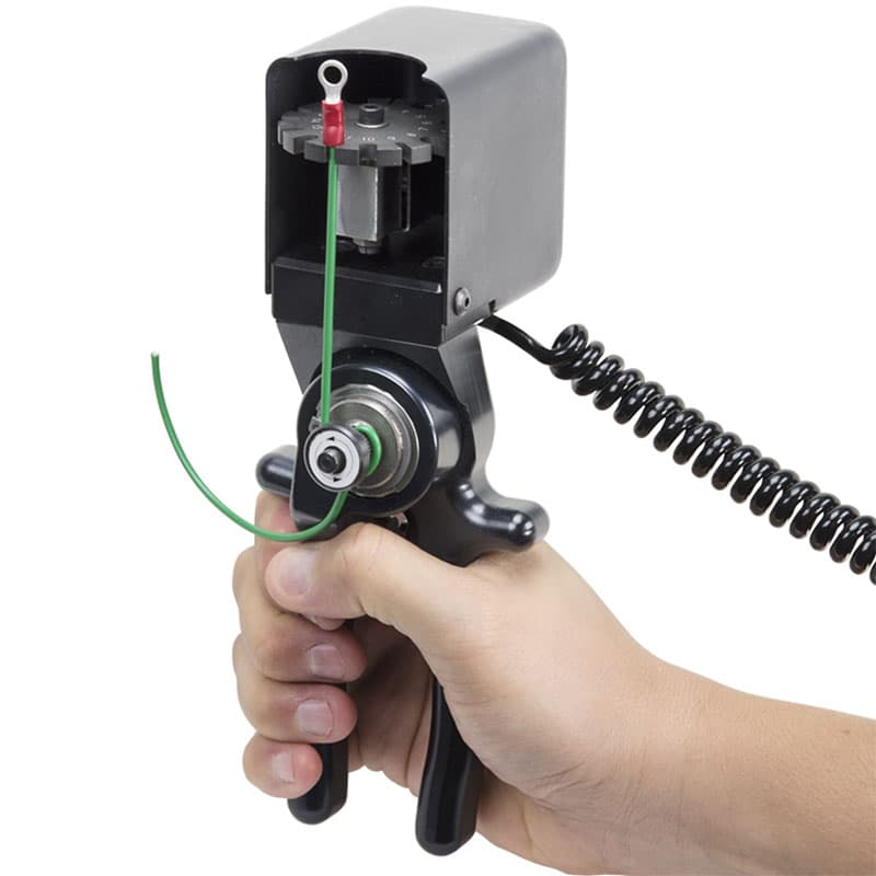 Operator using a Mark-10 Series R06 Wire Crimp Pull Sensor to test the pull strength of a crimped terminal on a green wire.