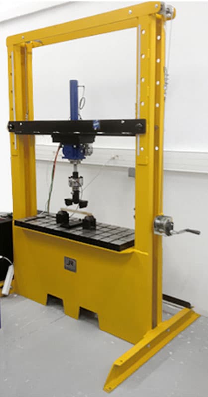 50 kN gantry-type electromechanical flexural testing machine with vertical loading actuator and adjustable test bed for controlled bending and structural load testing.