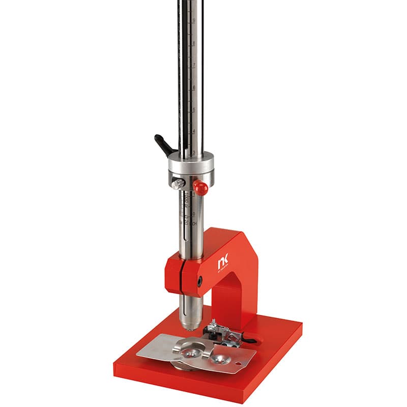 NK Paint Impact Tester with red support base, vertical graduated guide tube, adjustable release mechanism, and falling impact mass positioned above a coated test panel.