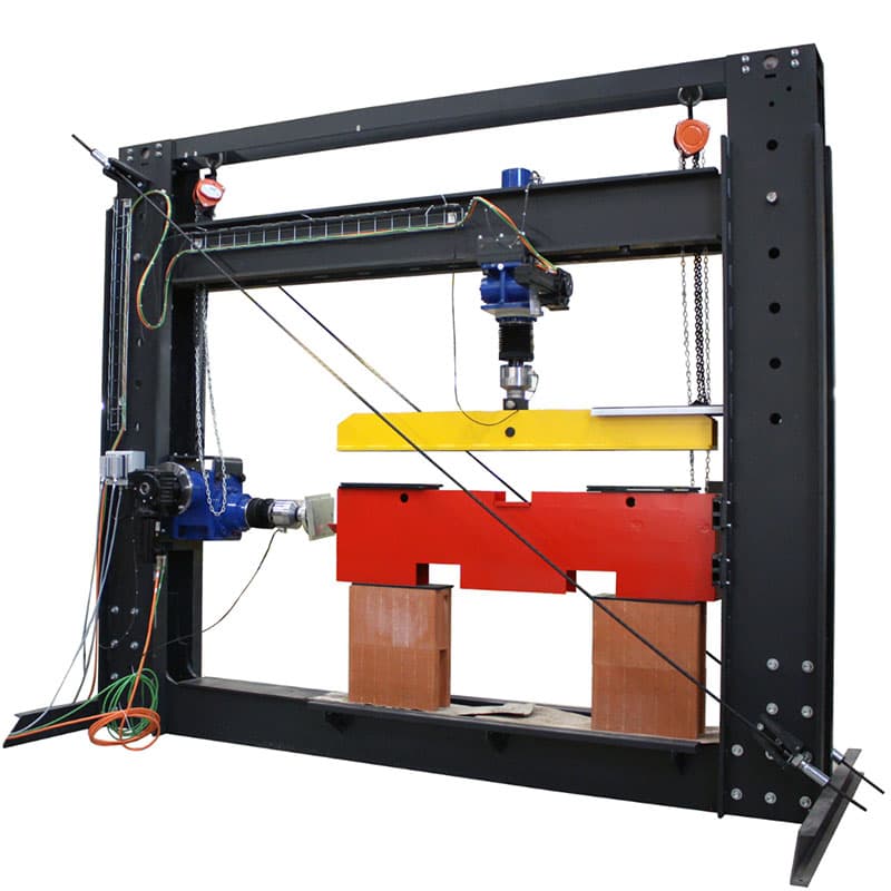 Wall shear testing machine with vertical and horizontal actuators mounted in a rigid reaction frame for applying controlled multidirectional loads to structural specimens.